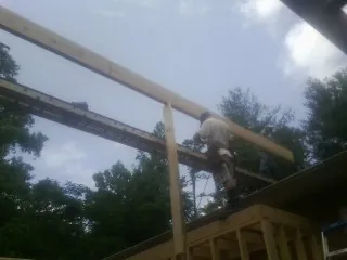 Carpenter setting a ridge beam over a new addition frame — Ice Dam Removal by Roofing Brothers in Moscow